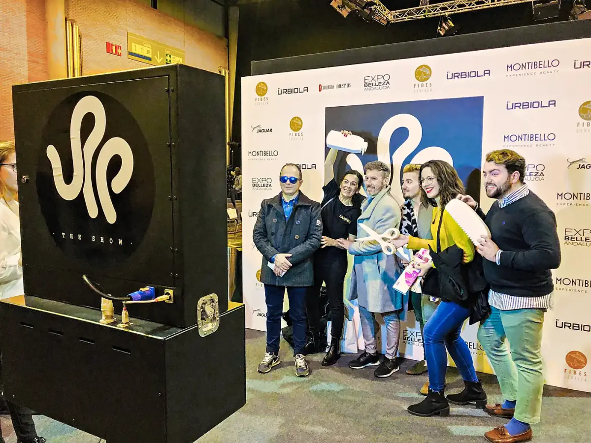 Asistentes Posando con Accesorios Junto a un Fotomatón Personalizado con la Marca del Cliente en una Feria Profesional Asistentes posando con accesorios junto a un fotomatón personalizado con la marca del cliente en una feria profesional.