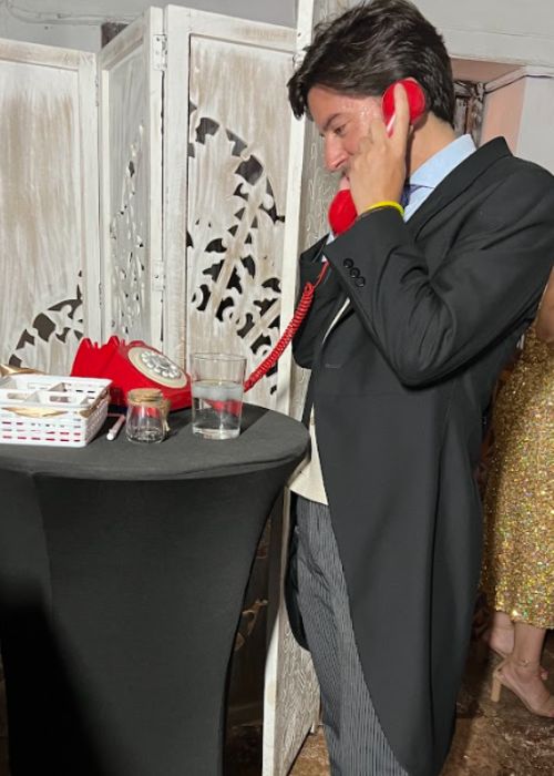 Novio en evento con teléfono rojo